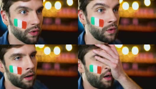 紧张的蓄着胡子的男球迷脸上挂着意大利国旗，捂着脸，球队输了高清在线视频素材下载