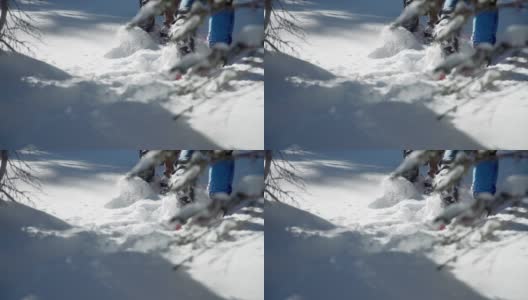 近距离慢动作拍摄的成人徒步者的脚离开相机雪鞋在深雪户外高清在线视频素材下载