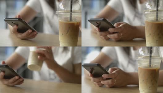 一名亚洲女性一边喝冷饮一边用智能手机发短信进行交流和在线社交聊天。高清在线视频素材下载