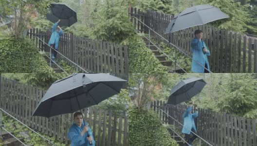 小男孩带着大雨伞在雨中行走高清在线视频素材下载