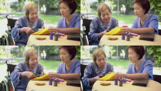 老年妇女与照顾者在针工艺职业治疗阿尔兹病高清在线视频素材下载