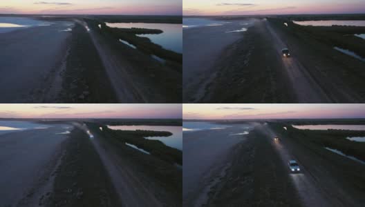 黄昏时分湖附近道路的鸟瞰图高清在线视频素材下载