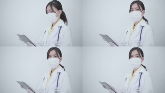 白袍女医生用平板电脑搜索一些疾病信息或阅读健康检查报告。高清在线视频素材下载