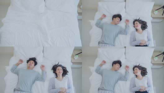 亚洲漂亮的快乐的年轻夫妇跳在床上休息在卧室。美丽的新婚男女穿着睡衣在清晨醒来和一起入睡后感到幸福和放松高清在线视频素材下载