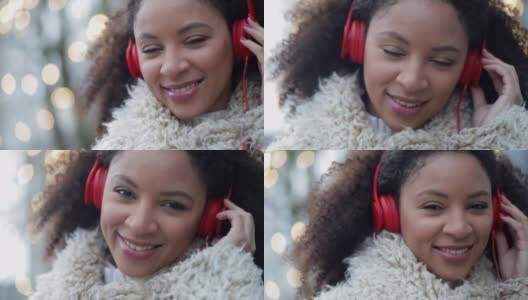 音乐女人听耳机。年轻的非洲裔美国妇女戴着耳机在户外听音乐和摆姿势高清在线视频素材下载