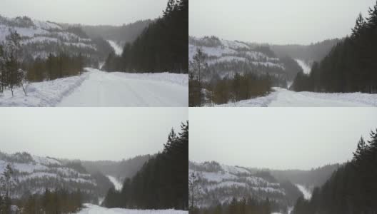 在多云的冬日，山坡上冬季道路的景象。镜头。一场暴风雪在一个冬天的老采石场的小路上的第一人称视角高清在线视频素材下载