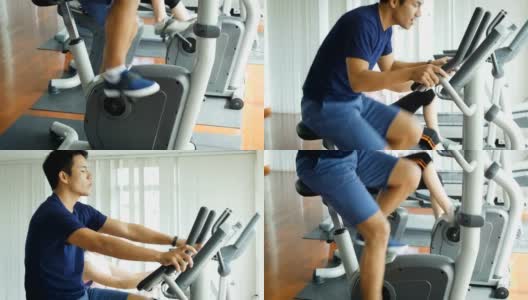 年轻的亚洲健身男子使用自行车在健身房锻炼自行车，有氧训练概念，倾斜相机拍摄高清在线视频素材下载