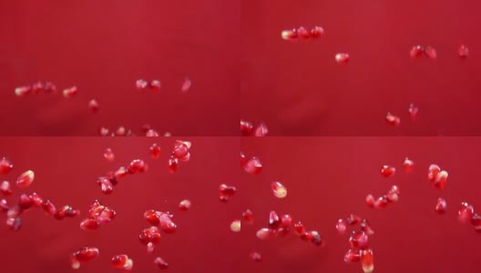 成熟的红石榴子在红色的背景上飞舞高清在线视频素材下载