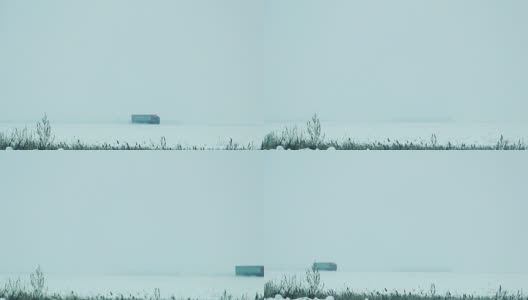 一辆带有红色小屋的卡车和一辆大货车快速地从左到右行驶在积雪覆盖的道路上高清在线视频素材下载