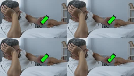 男人在智能手机上滚动绿色屏幕的网页，寻找新的应用程序高清在线视频素材下载