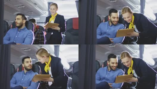 空姐向西班牙男性乘客展示带有菜单的平板电脑。他们在机上。商务舱的一个商业航空内部可见。高清在线视频素材下载