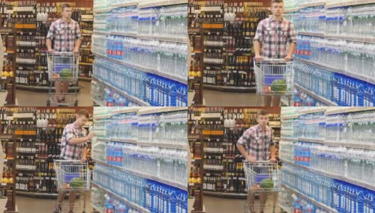 年轻人推着购物车在超市买水。一个人走进商店，拿着产品，一个人在店里买饮料高清在线视频素材下载