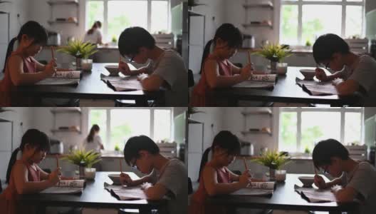 2个孩子在家学习写中国书法在餐厅高清在线视频素材下载