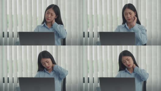 一位年轻的亚洲女性正坐在公司的办公室里，脖子很疼。高清在线视频素材下载