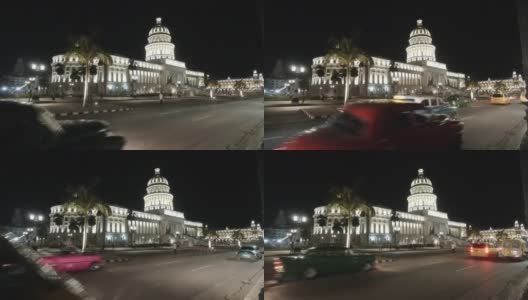 高清拍摄的老爷车通过城市街道的老哈瓦那与首都大厦的背景在哈瓦那，古巴晚上高清在线视频素材下载