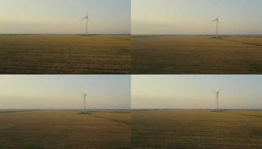 在一个美丽的夏日傍晚，鸟瞰乡间田野上的风车。高清在线视频素材下载