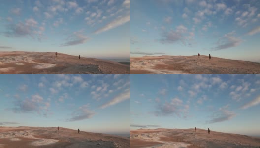 两名游客在壮丽明亮的天空下漫步于广袤的地热田高清在线视频素材下载