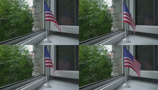 美国国旗立在架子上窗户上，在风中飘动。高清在线视频素材下载