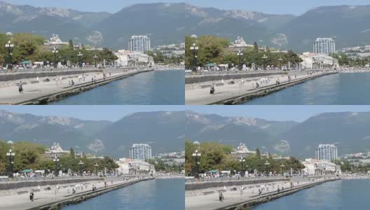 克里米亚雅尔塔——2018年5月1日:这座海滨城市的堤岸，人们在上面行走。一座山中的海城高清在线视频素材下载