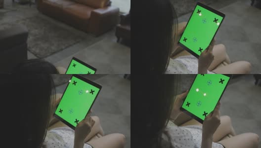 女孩在家里使用绿色屏幕的数字平板电脑高清在线视频素材下载