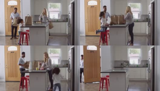 女孩和混血父母在厨房打开购物袋，拍摄于R3D高清在线视频素材下载