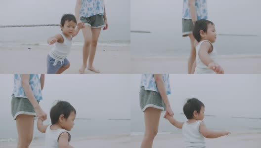 母亲和男婴在华欣海滩散步高清在线视频素材下载