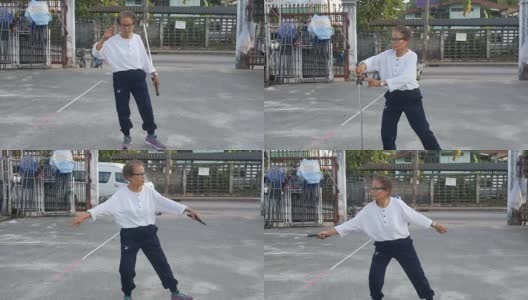 一位老妇人在停车场练习中国剑舞高清在线视频素材下载