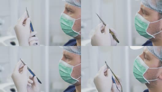 医生戴着无菌白手套和口罩在医院检查医疗器械。身着职业装的外科医生正在检查手上的夹钳高清在线视频素材下载