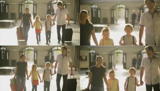 父母和孩子们都拿着旅行包站在车站，幸福的一家人一起旅行高清在线视频素材下载