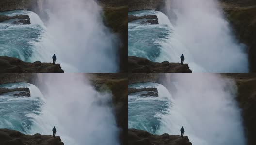 时间流逝的景观，在冰岛的海湾瀑布和人站在悬崖边，欣赏的观点高清在线视频素材下载