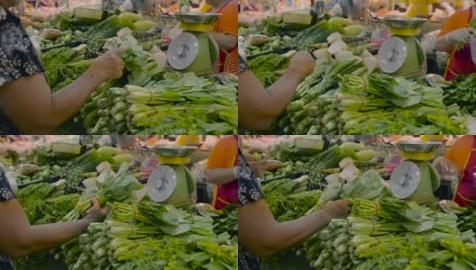 在市场上买新鲜蔬菜的女人。高清在线视频素材下载