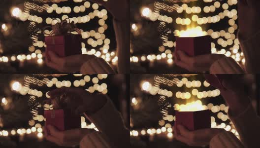 女人打开红色的圣诞礼盒，里面有金色的魔法灯高清在线视频素材下载
