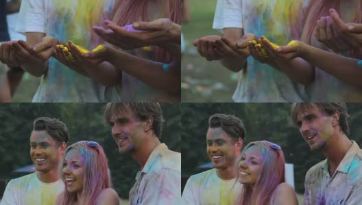 三个快乐的朋友拿着五颜六色的粉末颜料摆姿势，并把颜料抛向空中高清在线视频素材下载
