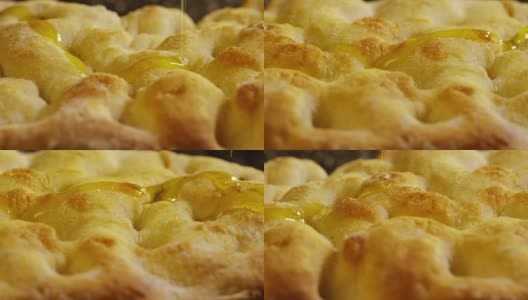 这是典型的意大利佛卡夏面包，在木板上慢慢地撒上盐和油。高清在线视频素材下载