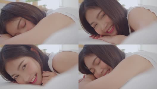 亚洲女人微笑躺在床上的卧室，美丽的日本女性使用放松时间后，在家里醒来。生活方式女性在家里使用放松时间的概念。高清在线视频素材下载