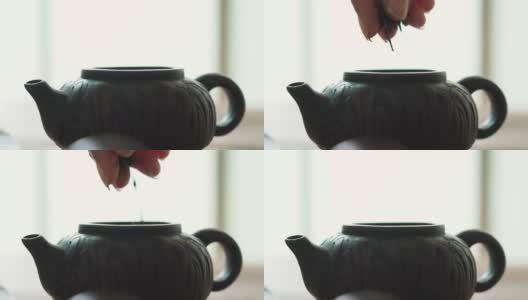 人们在茶壶里摘干茶叶高清在线视频素材下载