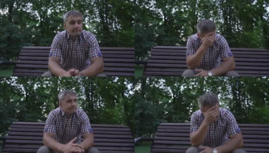 一名男子坐在城市公园的长椅上疲惫地揉着额头高清在线视频素材下载