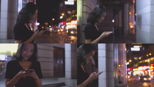 迷人的年轻亚洲女人在城市里使用手机的慢镜头高清在线视频素材下载