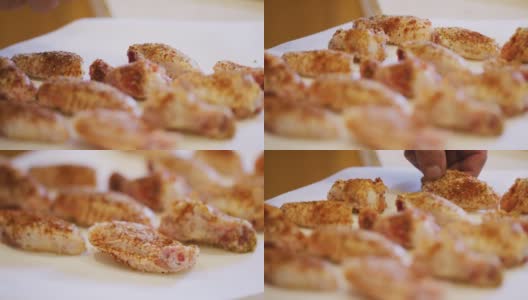 一名白种人的手将调味过的生鸡翅放在羊皮纸上准备烹饪高清在线视频素材下载