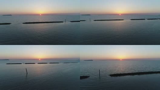 无人机飞，防波堤的石头在夕阳的海面上高清在线视频素材下载
