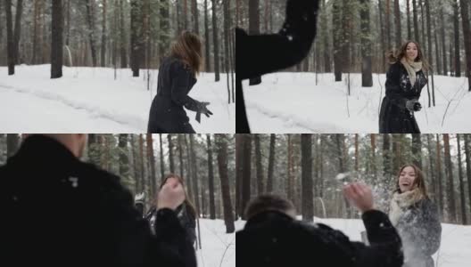 在一片冰雪覆盖的森林里，一对男女正在互相扔雪球高清在线视频素材下载
