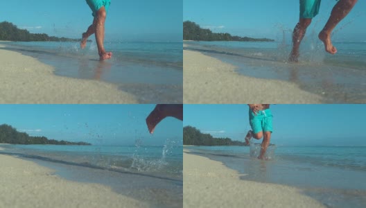 低角度:一个面目全非的男人赤脚跑在美丽的白色沙滩上。高清在线视频素材下载