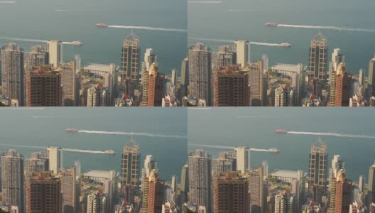 香港港口的高楼大厦与船只在平静的海水上疾驶-慢速高清在线视频素材下载