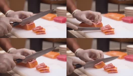 4K超高清慢动作手持:拉近厨师的手切生鲑鱼作为生鱼片，日本美食。高清在线视频素材下载