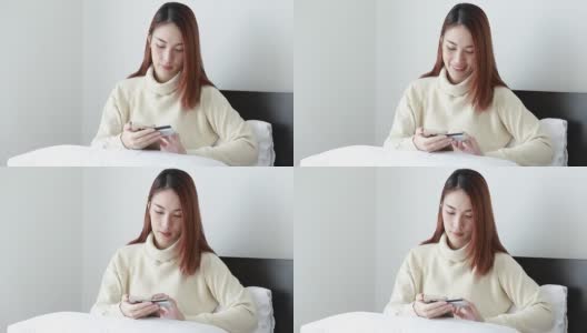 美丽的亚洲女人使用智能手机进行网上购物高清在线视频素材下载