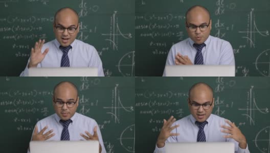 印度年轻教师男子坐着用笔记本电脑进行在线视频会议直播。亚洲数学教师在线授课，供学生在线学习。高清在线视频素材下载