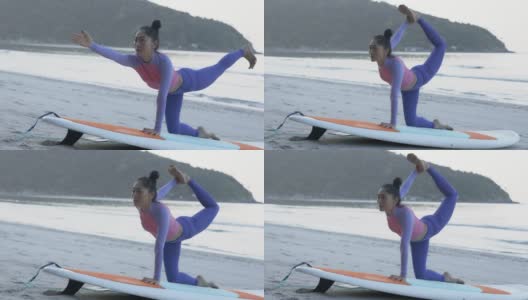 早上在海滩上，健康的亚洲美女在站立式划水板上做瑜伽练习。高清在线视频素材下载