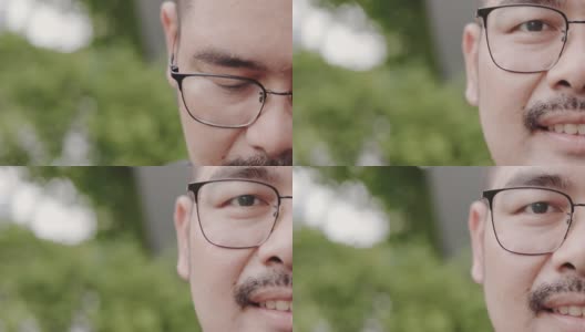 近肖像的脸迷人的亚洲男人与眼镜和胡子微笑自信享受成功。看着相机，很开心。男性的积极思考。肥胖的人健康高清在线视频素材下载