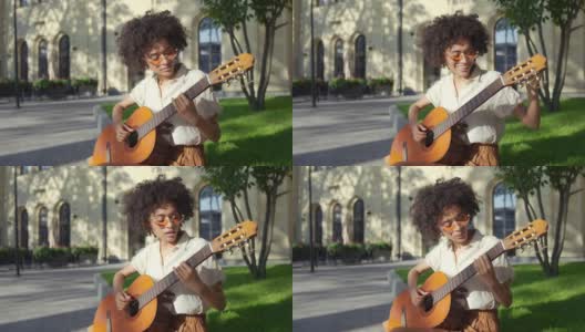 非裔美国女艺术家弹吉他和唱歌，街头表演高清在线视频素材下载