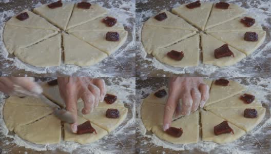 女人们的手拿着茶匙，放在生面团上的樱桃酱片上，用来做羊角面包。自制的甜糕点。果酱，生面团，由妇女在家庭厨房手工制作高清在线视频素材下载